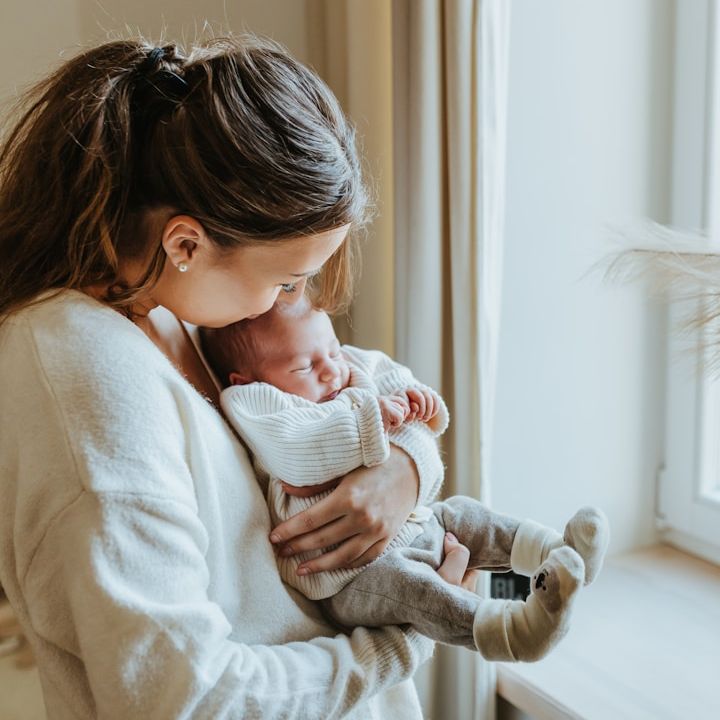 Glückliches Baby liegt entspannt in den Armen der Mutter – nach einfühlsamer digitaler Hebammenbegleitung.