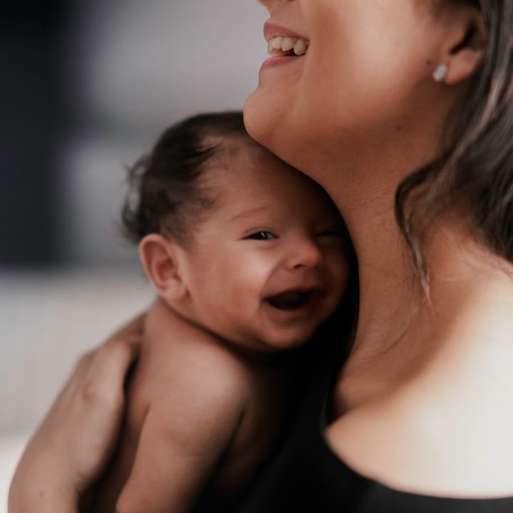 Frau hält ihr Baby liebevoll im Arm
