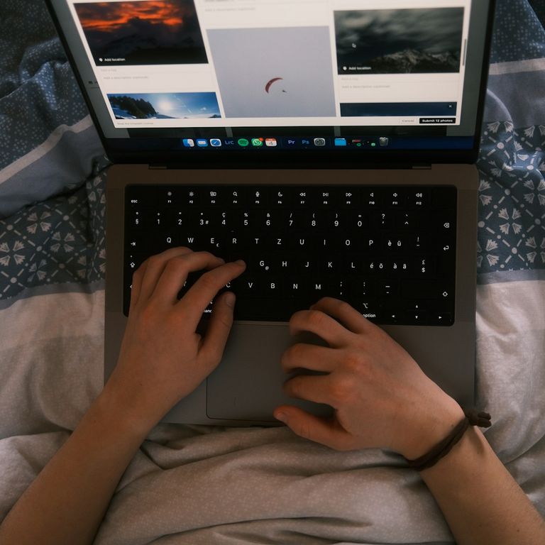 Schwangere Frau sitzt vor einem Laptop und nimmt an einem digitalen Geburtsvorbereitungskurs teil.